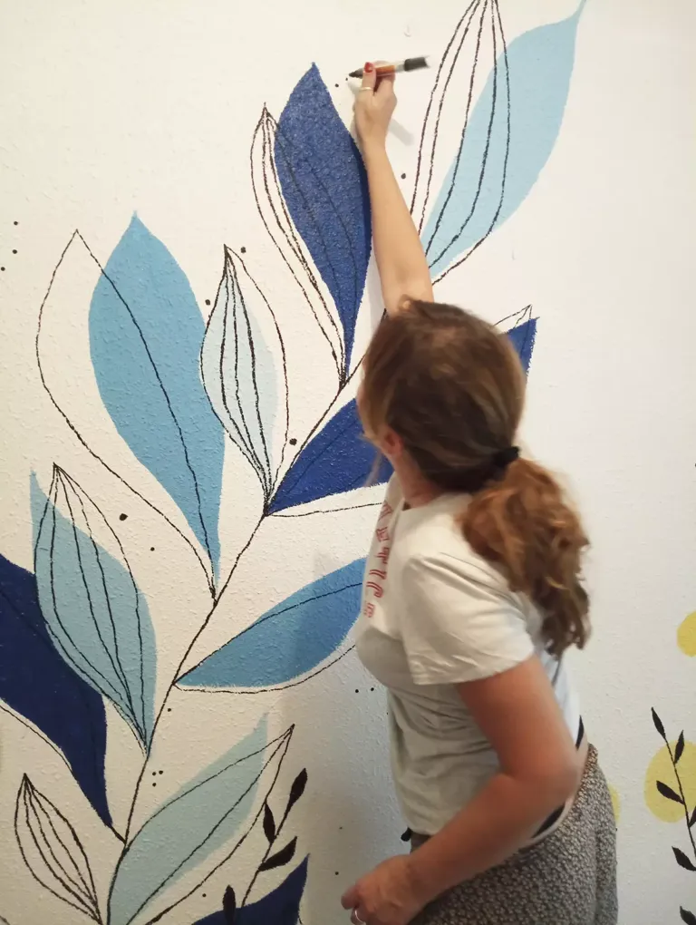 Cristina dibujando un mural