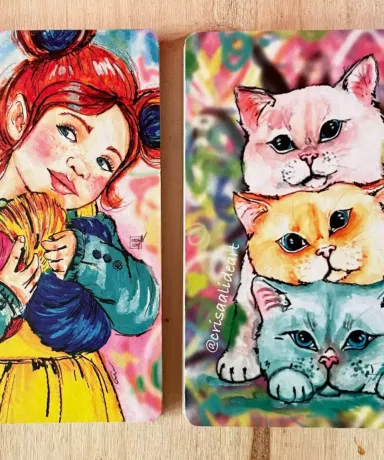 Dos libretas con ilustraciones en las tapas: una con gatos y otra con una niña