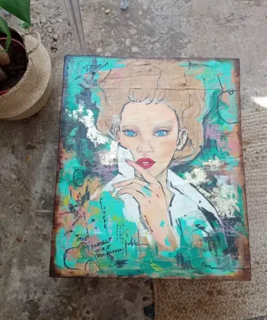 Mesa hecha con un palé con la ilustración de una mujer