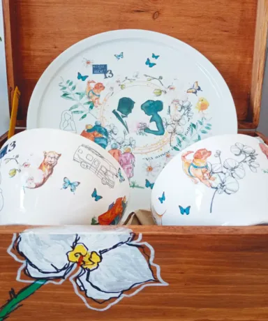 Vajilla con ilustraciones realizadas a acuarela en el interior de una caja de madera