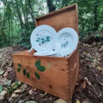Vajilla con ilustraciones de motivos florales realizadas a acuarela en el interior de una caja de madera